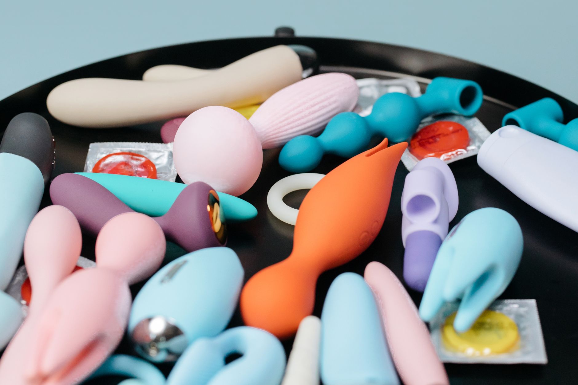Three colorful vibrators arranged on white fabric, highlighting smooth texture and design
