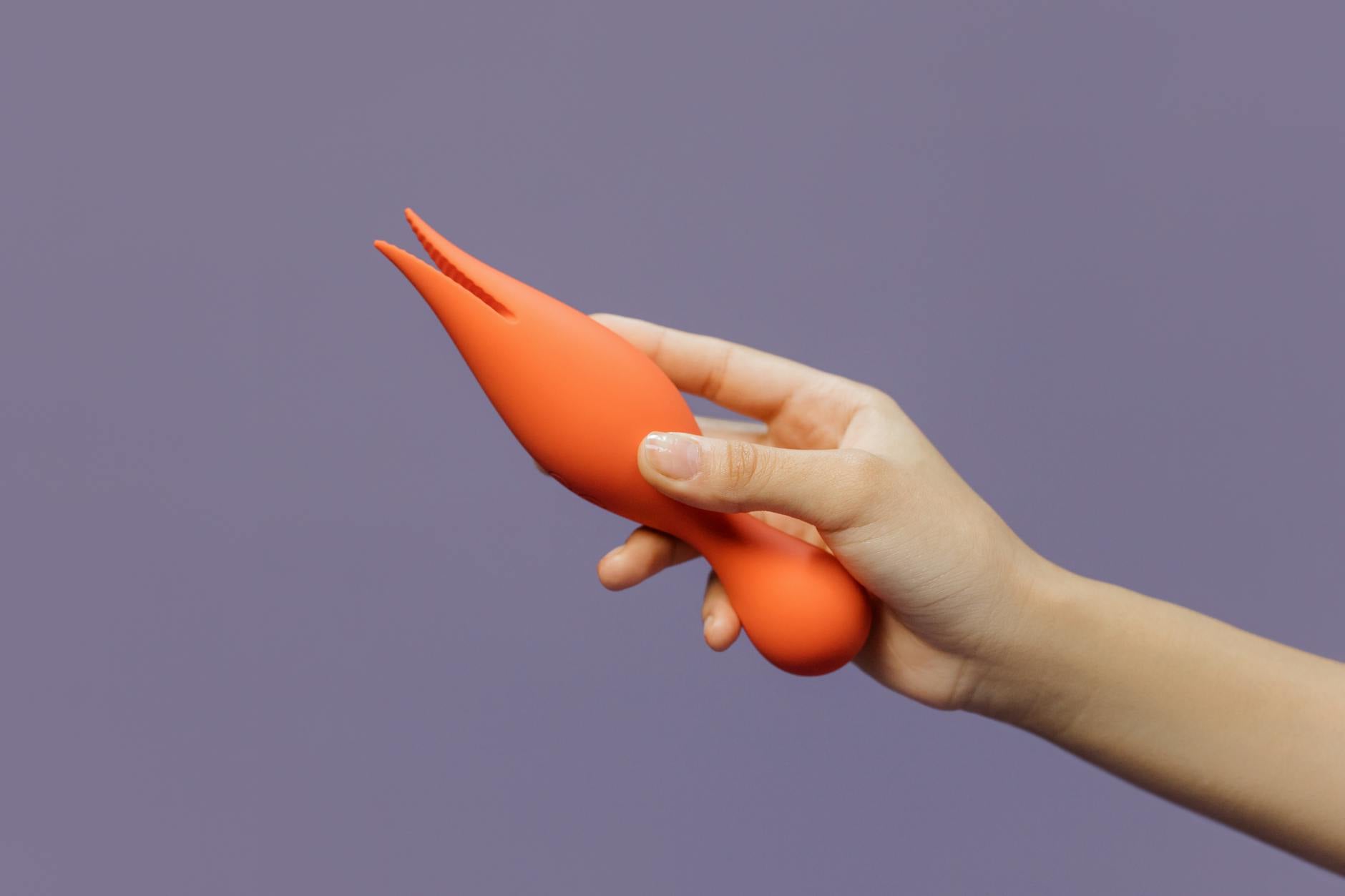 A young couple standing together indoors, exploring intimacy with a vibrator