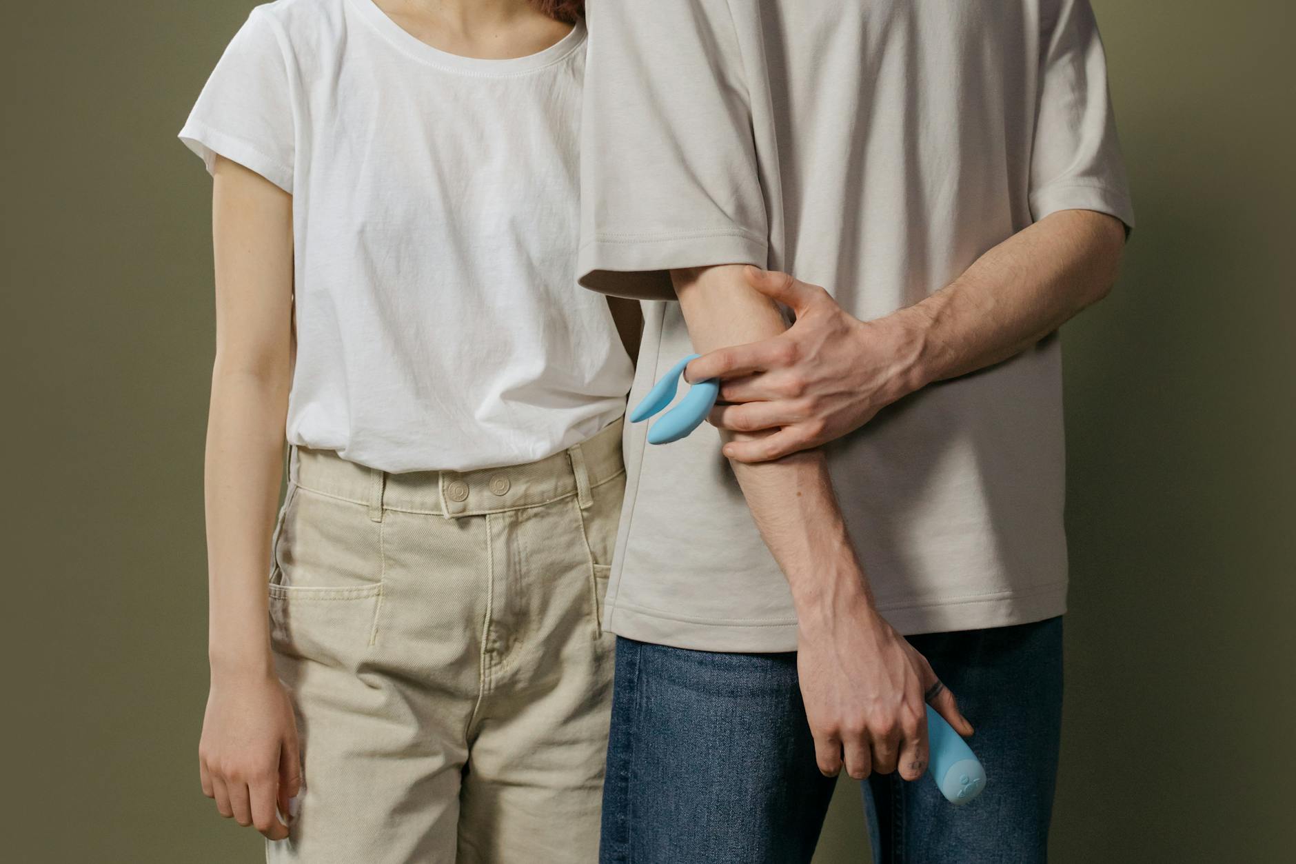 Hand holding a vibrator against a minimalist backdrop, representing pleasure and sensuality
